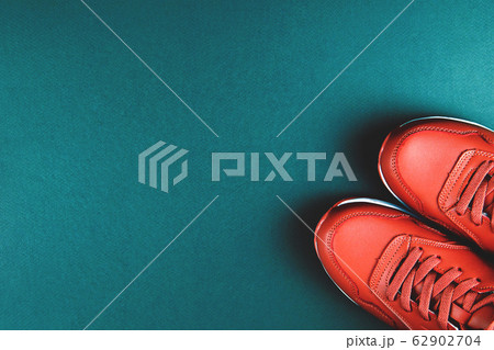 Red sneakers on blue background. Concept of sport and healthy lifestyle. Red sneakers on blue background. Concept of sport and healthy lifestyle. 62902704
