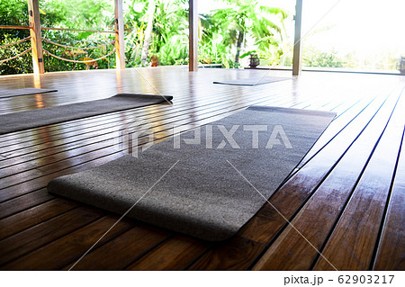 Open tropical yoga studio place with view outside to the beautiful garden with palm trees and ocean. 62903217