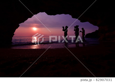 Silhouette of woman standing using camera to take Silhouette of woman standing using camera to take 62907031