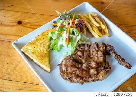 Black Pepper Pork Steak Food is popular in Asia, on a plate on a wooden floor. Black Pepper Pork Steak Food is popular in Asia, on a plate on a wooden floor. 62907250