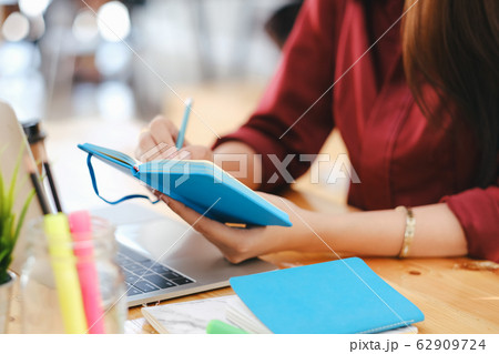 Close up female hands with pen writing on 62909724