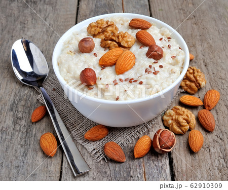 Oatmeal porridge with dried , nuts and raisin isolated on white backgrounds. Oatmeal porridge with dried , nuts and raisin isolated on white backgrounds. 62910309