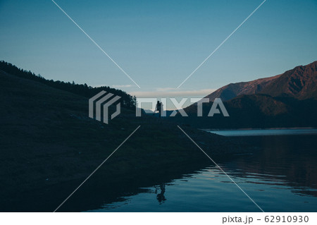 the concept of tourism, recreation, and travel - bursts of blue water in the river, mountains, and sky. A person travels. Copy space 62910930