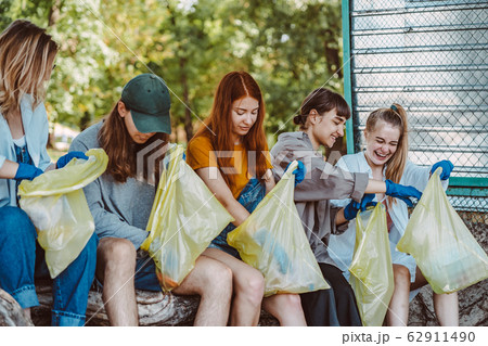 Group of activists friends collecting plastic waste at the park. Environmental conservation. Group of activists friends collecting plastic waste at the park. Environmental conservation. 62911490