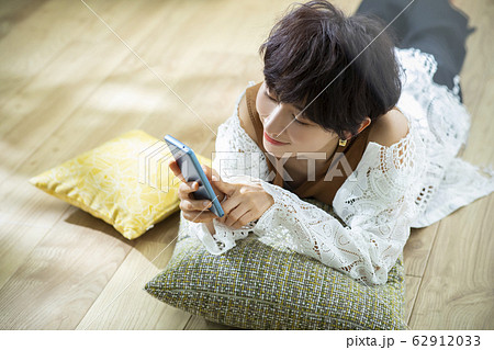 女性 ショートヘア 寝転ぶ スマホ スマートフォン 女性 ショートヘア 寝転ぶ スマホ スマートフォン 62912033