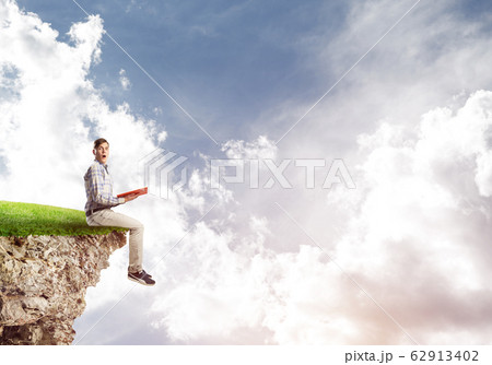 Student guy with book in hands preparing for exam Student guy with book in hands preparing for exam 62913402