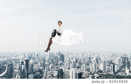 Businesswoman or accountant on cloud floating high above modern 62914930