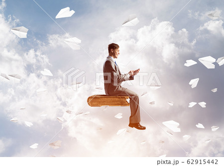 Businessman or student on book and paper planes flying around Businessman or student on book and paper planes flying around 62915442