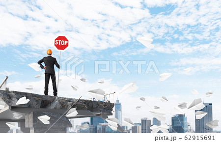 Confident engineer holding street safety sign. 62915691