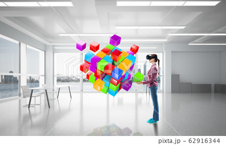 Girl in virtual reality mask experiencing virtual technology world. Mixed media 62916344