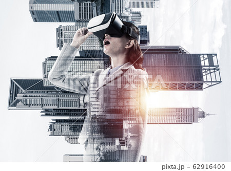 Woman in mask against sunrise above city trying virtual reality Woman in mask against sunrise above city trying virtual reality 62916400