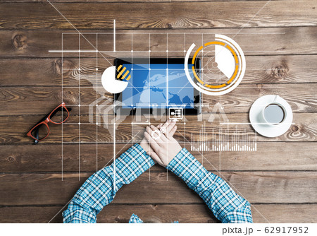 Business workplace with tablet device coffee cup and media graphs and diagrams 62917952