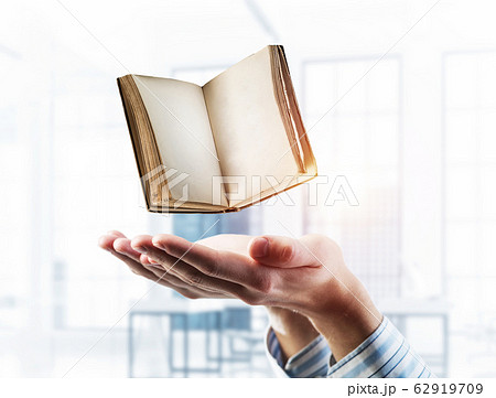 Education or writing concept with old book in male palms. Mixed Education or writing concept with old book in male palms. Mixed 62919709