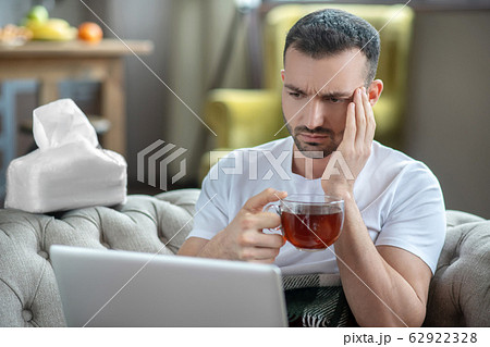 Dark-haired young man suffering from the headache 62922328