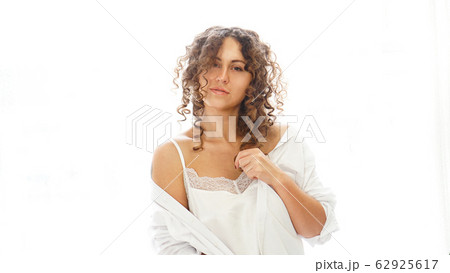 Sexy young woman in white shirt in bedroom - white light from window 62925617