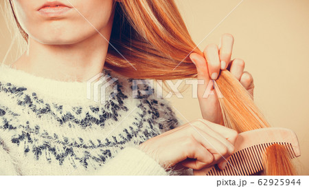 Teenage blonde girl brushing her hair with comb 62925944