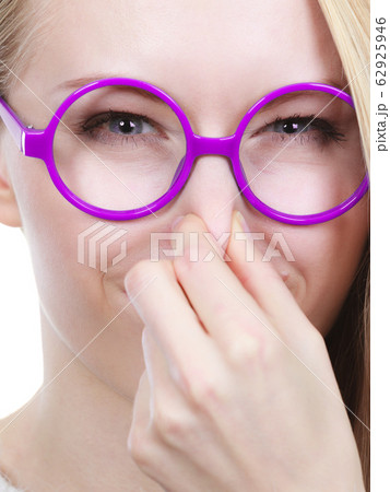 Nerdy woman holding nose smelling bad scent 62925946