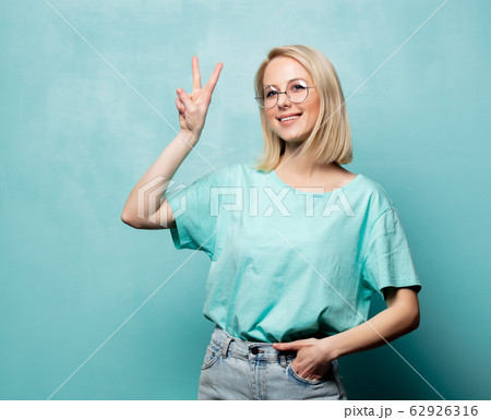 Style blonde woman in glasses show OK gesture on 62926316
