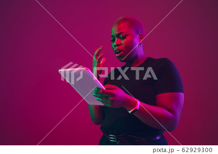 African-american young woman's portrait on purple pink background 62929300