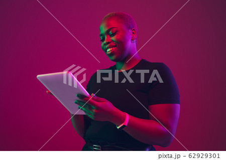 African-american young woman's portrait on purple pink background African-american young woman's portrait on purple pink background 62929301
