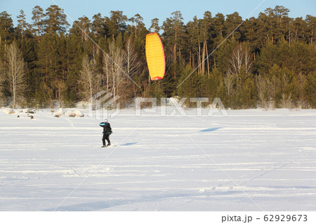 Man is engaged in snowkiting on the snowy surface 62929673
