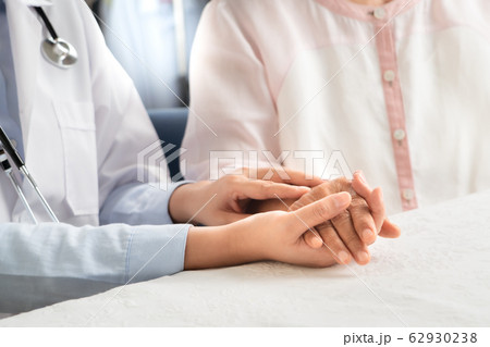 Doctor hands together holding senior woman patient 62930238