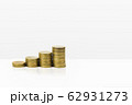 Growing stacked of coins on white table. 62931273