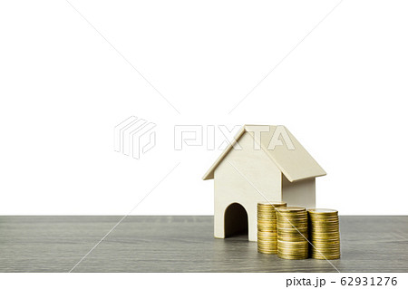 A small wooden house model with stack of coins. A small wooden house model with stack of coins. 62931276