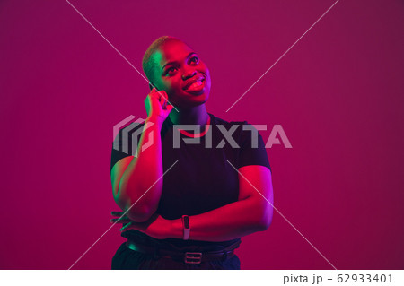 African-american young woman's portrait on purple pink background African-american young woman's portrait on purple pink background 62933401