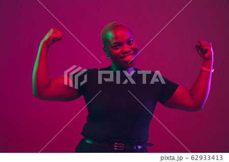 African-american young woman's portrait on purple pink background 62933413