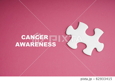 CANCER AWARENESS text with white jigsaw puzzle on 62933415
