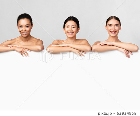 Three Women Smiling Posing Behind White Board, Free Space Three Women Smiling Posing Behind White Board, Free Space 62934958