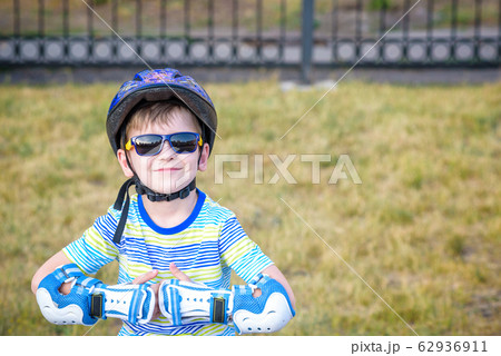 Little boy riding on rollers in the summer in the Little boy riding on rollers in the summer in the 62936911