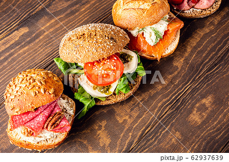 Assorted sandwiches on wooden table Assorted sandwiches on wooden table 62937639