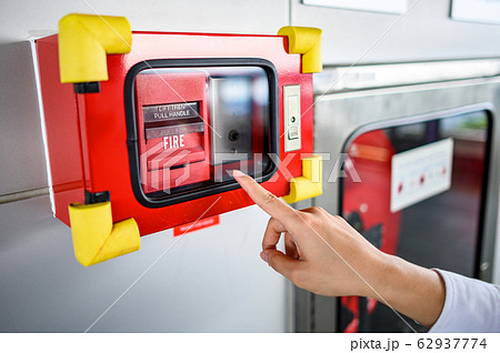 Male hand pointing at red fire alarm switch 62937774