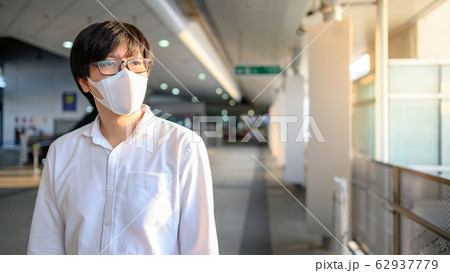 Asian man wearing mask at skytrain station Asian man wearing mask at skytrain station 62937779