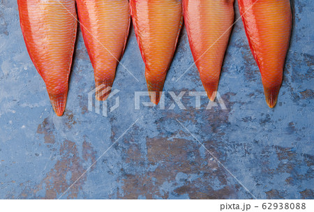 Beautiful tropical red sea fish Pearly razorfish on a blue background. Galan fish Xyrichtys novacula, seafood from Mediterranean Sea. Beautiful tropical red sea fish Pearly razorfish on a blue background. Galan fish Xyrichtys novacula, seafood from Mediterranean Sea. 62938088