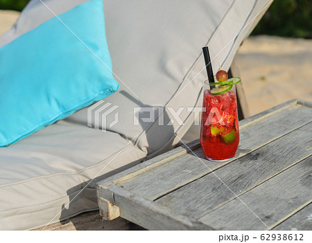 Glass of fruit juice on a beach table 62938612