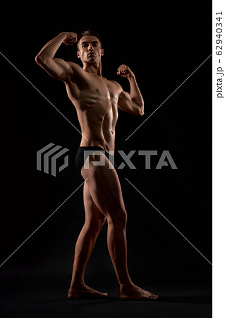 Male bodybuilder demonstrating contest pose. Male bodybuilder demonstrating contest pose. 62940341