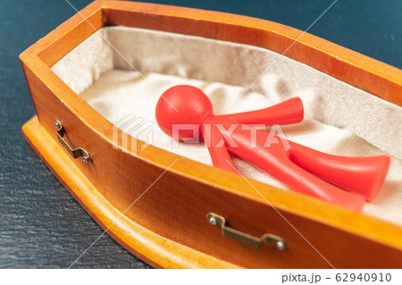 COVID-19 concept. Red bright coloured figurine in coffin COVID-19 concept. Red bright coloured figurine in coffin 62940910