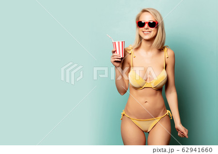 Beautiful blonde woman in bikini with paper cup 62941660