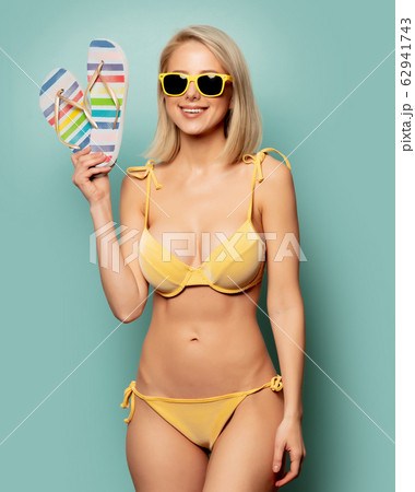 woman in yellow bikini and sunglasses with woman in yellow bikini and sunglasses with 62941743