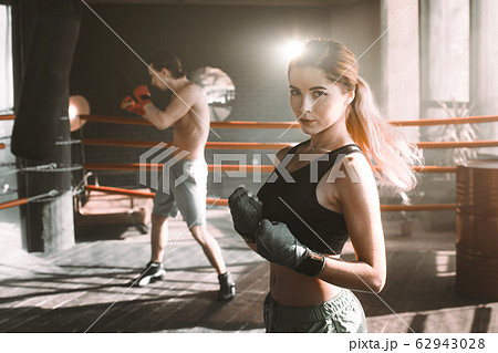 Female boxer doing shadow boxing inside a boxing ring. Boxer practicing her moves at a boxing studio. 62943028