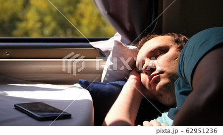 Man sleeps in train tired long journey by rail Man sleeps in train tired long journey by rail 62951236
