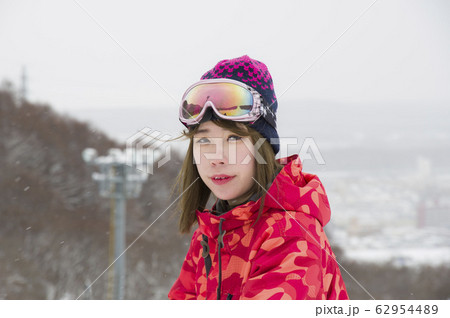 小雪舞うスキーゲレンデと女性スキーヤー 小雪舞うスキーゲレンデと女性スキーヤー 62954489