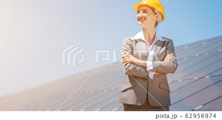Woman investor in clean energy standing in front of solar panels Woman investor in clean energy standing in front of solar panels 62956974