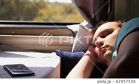 Man sleeps in train tired long journey by rail 62957530