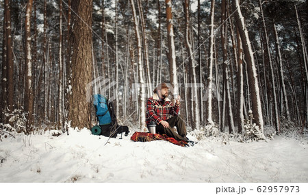 Outdoorsman drinking tea, winter forest 62957973
