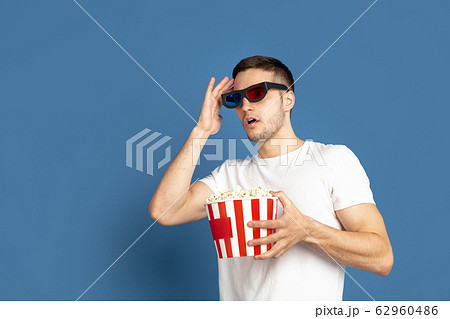 Caucasian young man's portrait on blue studio background 62960486