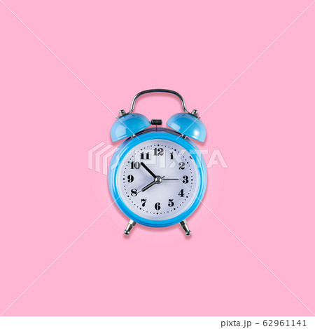 Blue vintage alarm clock on light pink color Blue vintage alarm clock on light pink color 62961141
